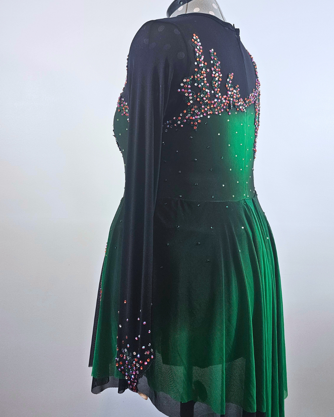 custom black and green figure skate dress with orange and purple stones